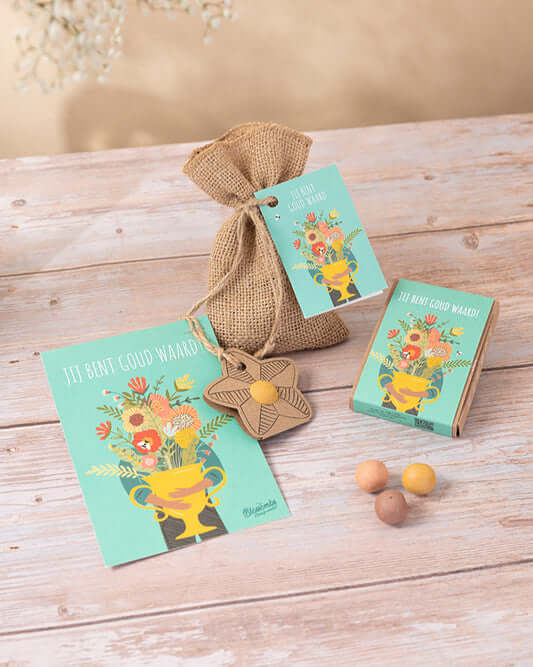 Gift box with seed bombs and floral design, labeled 'Jij bent goud waard', perfect for gifts.